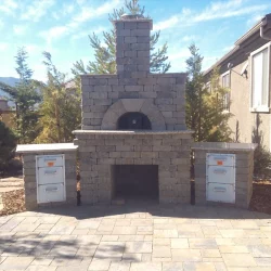Backyard landscape with a stone fireplace and pizza oven