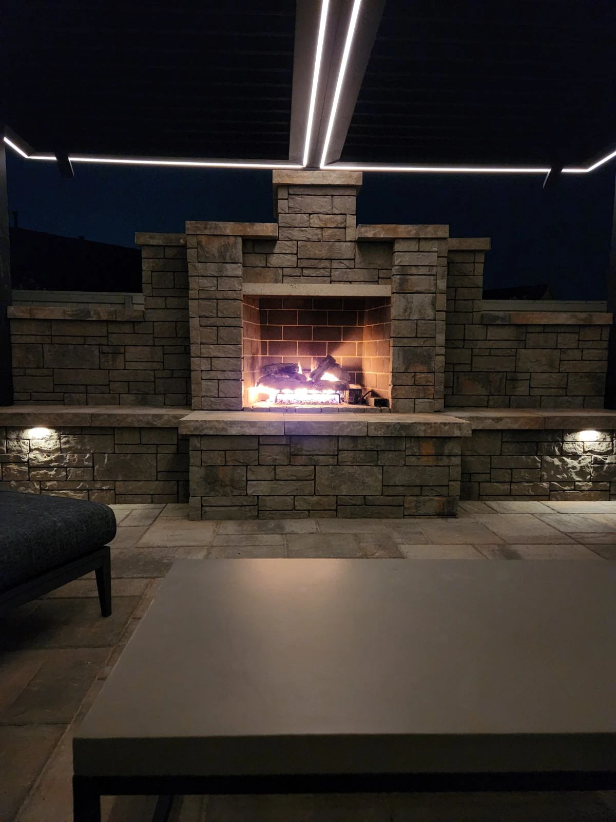 Outdoor living area night scene with fireplace